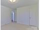 Empty bedroom with light carpet, white walls, and doorway to another room at 1630 26Th Ne St, Hickory, NC 28601