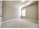 This is a bedroom with neutral colored walls, carpet, and a single window at 1891 Felts Pkwy, Fort Mill, SC 29715