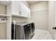 Well-equipped laundry room features modern washer and dryer, built-in cabinetry, and tile flooring for easy maintenance at 1891 Felts Pkwy, Fort Mill, SC 29715