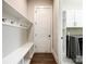Functional mud room with a built-in bench, hooks, and adjacent laundry room, perfect for organization and convenience at 1891 Felts Pkwy, Fort Mill, SC 29715