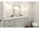 Clean white bathroom featuring a large mirror and under sink storage at 1922 Hamorton Pl, Charlotte, NC 28205