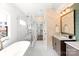 Modern bathroom features a glass-enclosed shower, soaking tub, and vanity with elegant fixtures and patterned wallpaper at 1922 Hamorton Pl, Charlotte, NC 28205