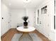 Stylish foyer with a round marble table, unique plant, shiplap wall, and natural light from glass paneled front door at 1922 Hamorton Pl, Charlotte, NC 28205