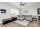 Comfortable living room with a large window, ceiling fan, and stylish sectional sofa at 19613 Feriba Pl, Cornelius, NC 28031