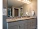 Bathroom featuring a double sink vanity with granite countertops, decorative fixtures, and a large mirror at 2010 Saddlebred Dr, Iron Station, NC 28080