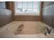 Luxurious soaking tub with a wooden caddy in a serene bathroom setting at 2010 Saddlebred Dr, Iron Station, NC 28080
