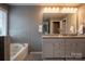 Elegant bathroom featuring double vanity sinks, granite countertops, and a luxurious soaking tub at 2010 Saddlebred Dr, Iron Station, NC 28080