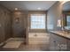 Bathroom with a shower and separate tub, tiled walls and floors, and granite countertop vanity at 2010 Saddlebred Dr, Iron Station, NC 28080