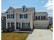 Charming two-story home featuring a well-manicured lawn and attached two-car garage at 2010 Saddlebred Dr, Iron Station, NC 28080
