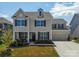 Charming two-story home with a well-manicured lawn, dormer, and attached two-car garage at 2010 Saddlebred Dr, Iron Station, NC 28080