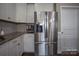 Stainless steel refrigerator complementing white cabinetry and granite countertops in the kitchen at 2010 Saddlebred Dr, Iron Station, NC 28080