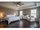 Well-lit main bedroom featuring hardwood floors, a tray ceiling, and dual sitting chairs at 2010 Saddlebred Dr, Iron Station, NC 28080