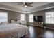 Bright main bedroom with hardwood floors, a tray ceiling, ceiling fan, and plenty of natural light at 2010 Saddlebred Dr, Iron Station, NC 28080