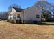 Exterior view showcases the side of the house with a small deck and a well-manicured lawn at 2037 Powerline Dr, Gastonia, NC 28054