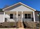 Inviting covered porch with brick base, decorative railings and a prominent front door at 2037 Powerline Dr, Gastonia, NC 28054