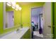Bright bathroom featuring colorful walls, a vanity with sink, and a glimpse into an adjacent bedroom at 214 Harrel St, Salisbury, NC 28144