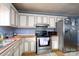 Cozy kitchen featuring painted cabinets, stainless steel appliances, and light-colored countertops at 214 Harrel St, Salisbury, NC 28144