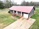 Cozy home featuring a metal roof, brick foundation, white trim, and an attached one-car garage at 2180 Grace Church Rd, Salisbury, NC 28147