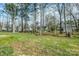 Lush backyard with mature trees surrounding neighboring houses on a partially sunny day at 2583 Watson Dr, Lancaster, SC 29720