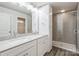 Bright bathroom with a double vanity, white cabinets, a glass shower, and wood-look flooring at 2591 Watson Dr, Lancaster, SC 29720
