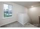 Upstairs hallway with neutral carpet and paint with a large window letting in natural light at 2591 Watson Dr, Lancaster, SC 29720