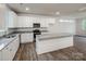 Modern kitchen with white cabinets, stainless steel appliances, granite countertops, and wood flooring at 2591 Watson Dr, Lancaster, SC 29720