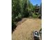 View of the backyard including a shed and surrounded by a forest at 2822 Woodlands Creek Dr, Monroe, NC 28110