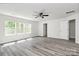 Bright bedroom with natural light, ceiling fan, modern flooring, and a classic white door at 2822 Woodlands Creek Dr, Monroe, NC 28110