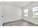 Sunny bedroom offers two windows, neutral walls, and modern flooring for a comfortable, bright space at 2822 Woodlands Creek Dr, Monroe, NC 28110