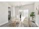 Bright dining room with a glass table, modern chandelier, and large windows at 2822 Woodlands Creek Dr, Monroe, NC 28110