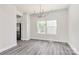 Bright dining room featuring stylish chandelier, natural light, and sleek gray flooring at 2822 Woodlands Creek Dr, Monroe, NC 28110