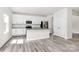 Bright white kitchen with stainless steel appliances and gray wood floors at 2822 Woodlands Creek Dr, Monroe, NC 28110