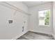 Functional laundry room featuring a window, ample lighting, and organized storage solutions at 2822 Woodlands Creek Dr, Monroe, NC 28110