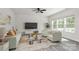 Comfortable living room featuring large windows, stylish furniture, and a ceiling fan at 2822 Woodlands Creek Dr, Monroe, NC 28110