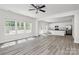 Open-concept living room with a view of modern kitchen and stainless steel appliances at 2822 Woodlands Creek Dr, Monroe, NC 28110