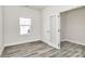 Bright room with window and doorway with glass door with gray wood floors at 2822 Woodlands Creek Dr, Monroe, NC 28110