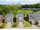 Aerial view of a home situated near a pond, surrounded by lush greenery and with the city skyline in the distance at 3614 Dolly Madison Rd, Charlotte, NC 28208