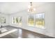 Sun-filled living room featuring large windows, dark wood flooring, and access to the backyard at 3614 Dolly Madison Rd, Charlotte, NC 28208
