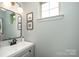 Stylish powder room featuring a modern vanity, mirror, and natural light at 3614 Dolly Madison Rd, Charlotte, NC 28208