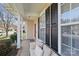 Cozy porch with a cushioned bench seat, white columns, black shutters, and a bright red front door at 3812 Caldwell Ridge Pkwy, Charlotte, NC 28213
