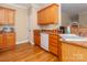 A kitchen showcasing wood cabinets, a white dishwasher, and wood-look floors at 3816 Sonoma Way, Monroe, NC 28110