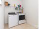 Modern laundry room with a washer, dryer, and overhead shelving at 3816 Sonoma Way, Monroe, NC 28110