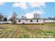 Back exterior view of home showcasing windows, white siding and partial yard at 405 Briarwood Ct, Mount Holly, NC 28120