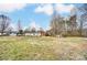 Large grassy backyard featuring mature trees at 405 Briarwood Ct, Mount Holly, NC 28120