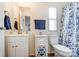 Bathroom with white vanity, mirrored medicine cabinet, and blue floral shower curtain at 405 Briarwood Ct, Mount Holly, NC 28120