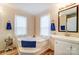 Bright bathroom features a corner soaking tub with blue accents at 405 Briarwood Ct, Mount Holly, NC 28120