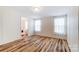 Bright bedroom features wood-look flooring and ensuite bathroom access at 405 Briarwood Ct, Mount Holly, NC 28120