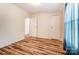 Bright bedroom with wood-look flooring, white walls, and natural light at 405 Briarwood Ct, Mount Holly, NC 28120