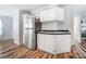 Kitchen with stainless steel refrigerator, white cabinets, and wood-look flooring at 405 Briarwood Ct, Mount Holly, NC 28120