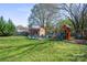 Large backyard with a playset, shed, mature trees, and open space for outdoor activities at 41 Selma Dr, Mooresville, NC 28115